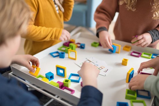 Kinderen spelen samen met rustig Montessori speelgoed aan tafel