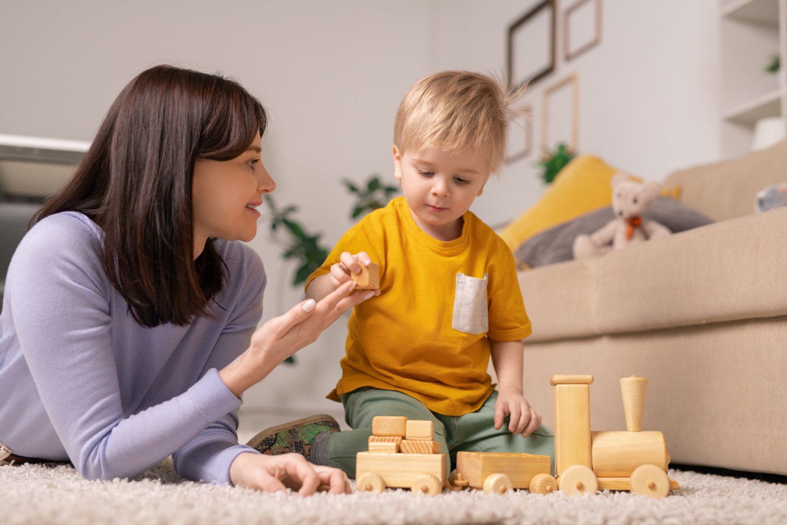 Moeder en peuter spelen samen met houten blokken, speelgoed abonnement vergelijking