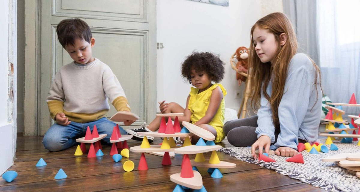 Drie kinderen bouwen op de vloer met OPPI Piks