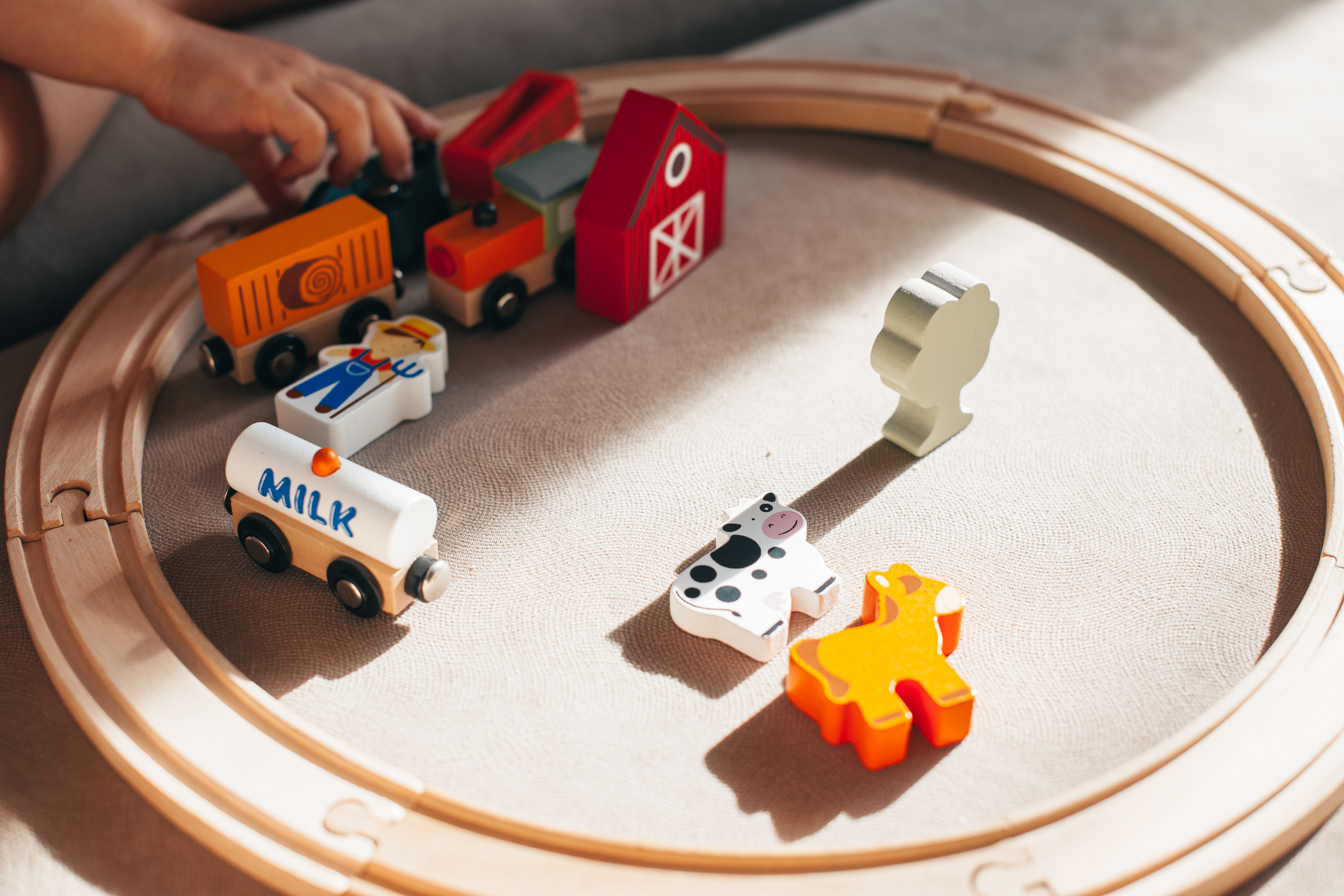 Kinderhanden spelen met een houten treinbaan en een paar houten voertuigen, speelgoed roteren